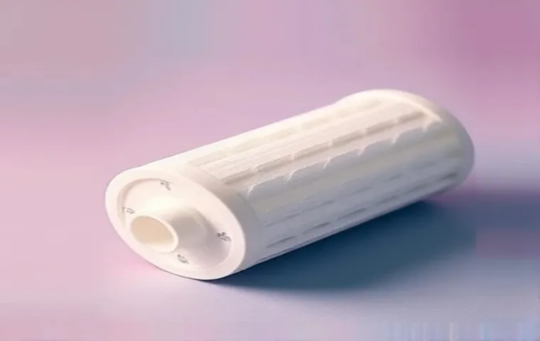 فیلتر الیافی تصفیه آب سفید رنگ، با بافت ریز و استوانهای، قرار گرفته روی سطحی با پسزمینهی رنگی با طیفهای صورتی و آبی